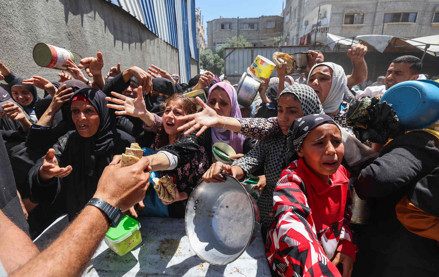 Palestinians queue for a hot meal at a charity kitchen run by the United Nation's World Food Programme (WFP) at the Nuseirat refugee camp in the central Gaza Strip on April 26, 2025.
