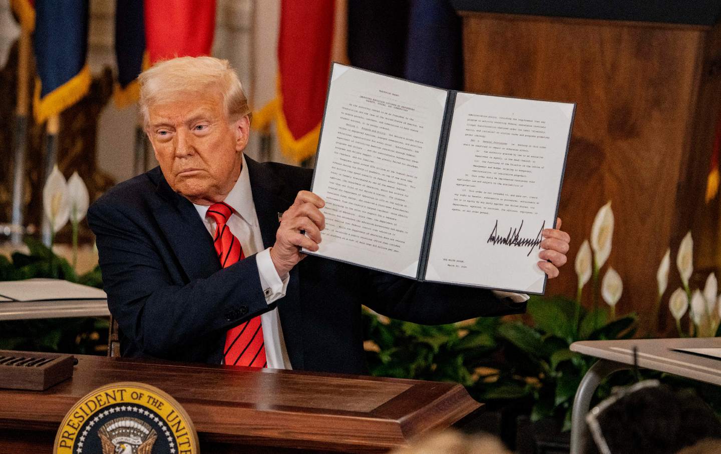 President Donald Trump signs an executive order to eliminate the Department of Education in Washington, DC, on March 20, 2025.
