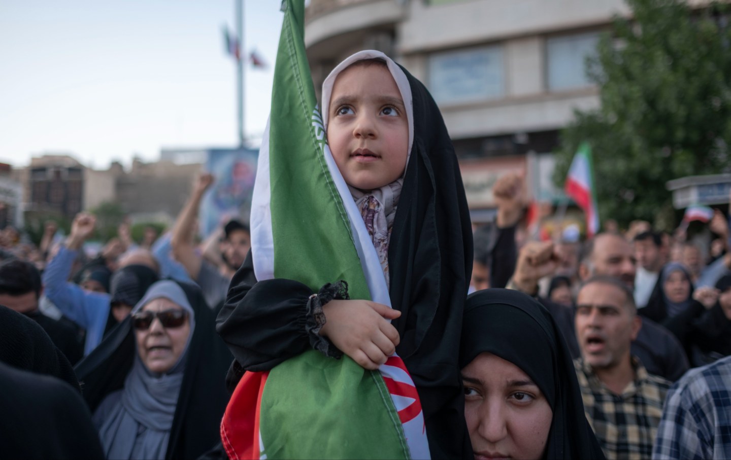 A young Iranian girl holds a country flag during a protest to condemn the U.S. attacks on Iran's nuclear facilities in downtown Tehran, Iran, on June 22, 2025