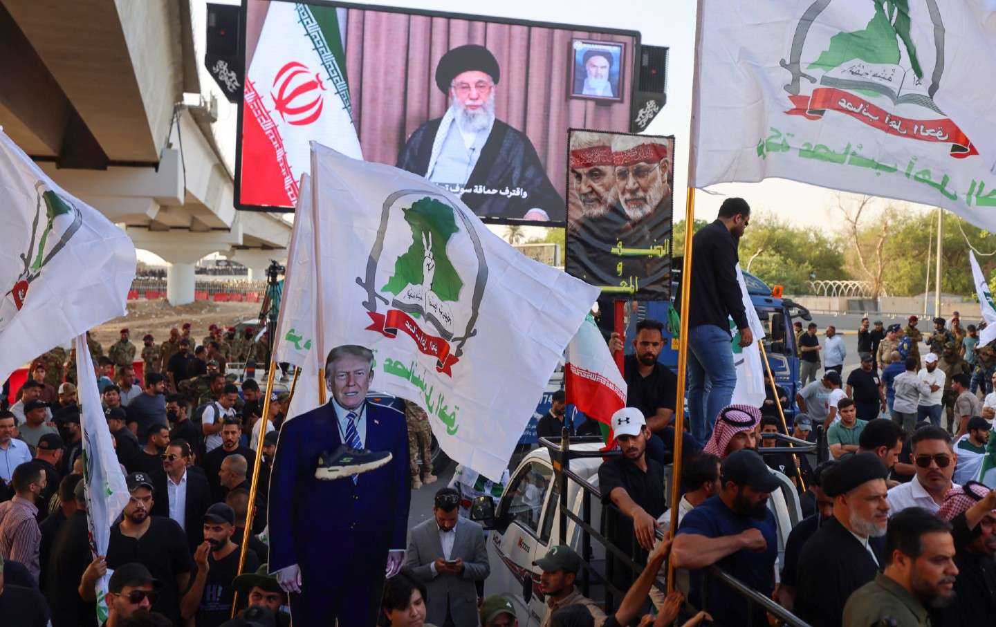 Supporters of Iraqi pro-Iran groups hold a cutout of US President Donald Trump during a protest in Baghdad near the US embassy, on June 16, 2025.